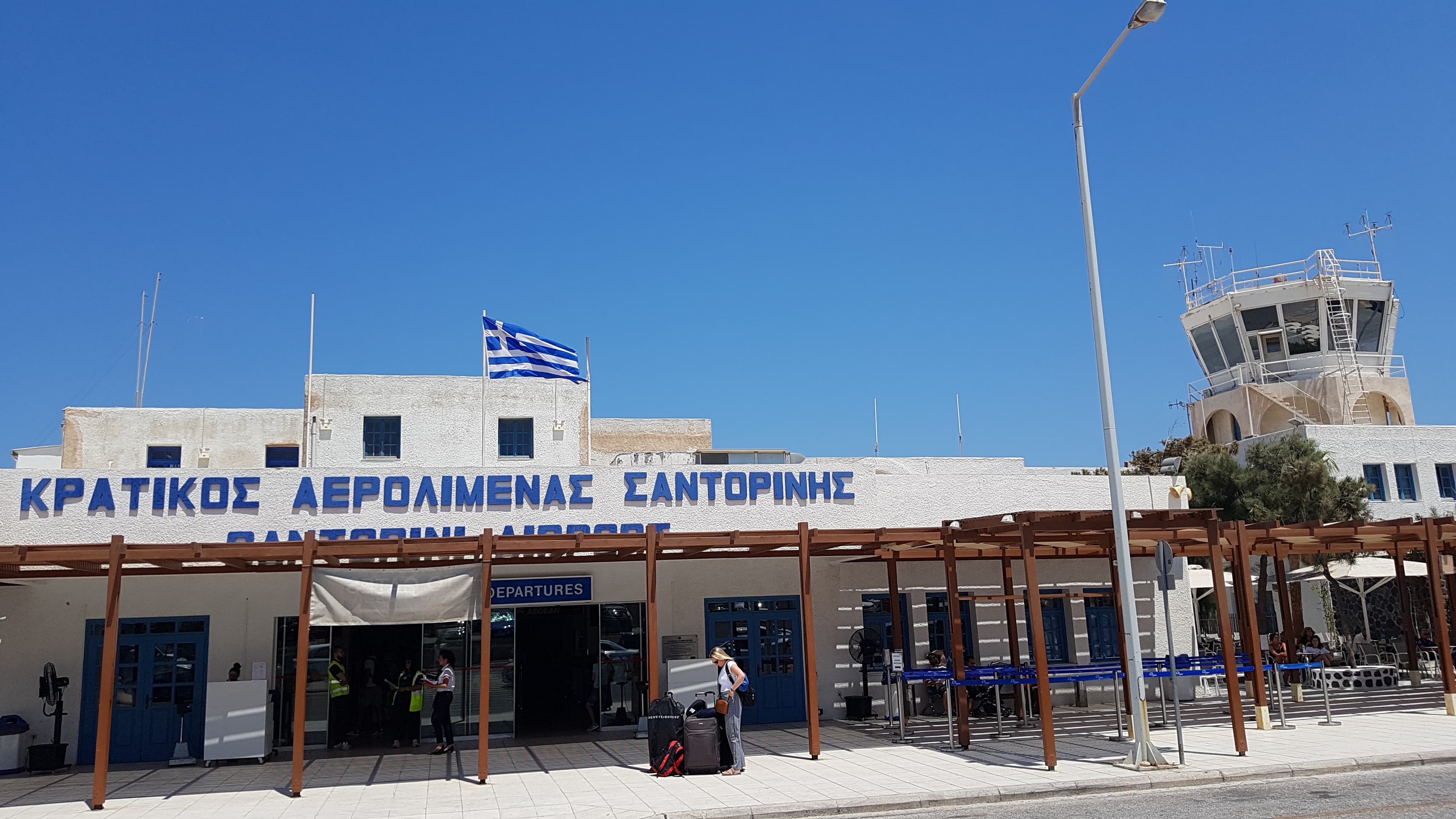 Photo: Lacu Schienred, CC BY-SA 4.0, via Wikimedia Commons (https://commons.wikimedia.org/wiki/File:Santorini_Airport_Building.jpg)