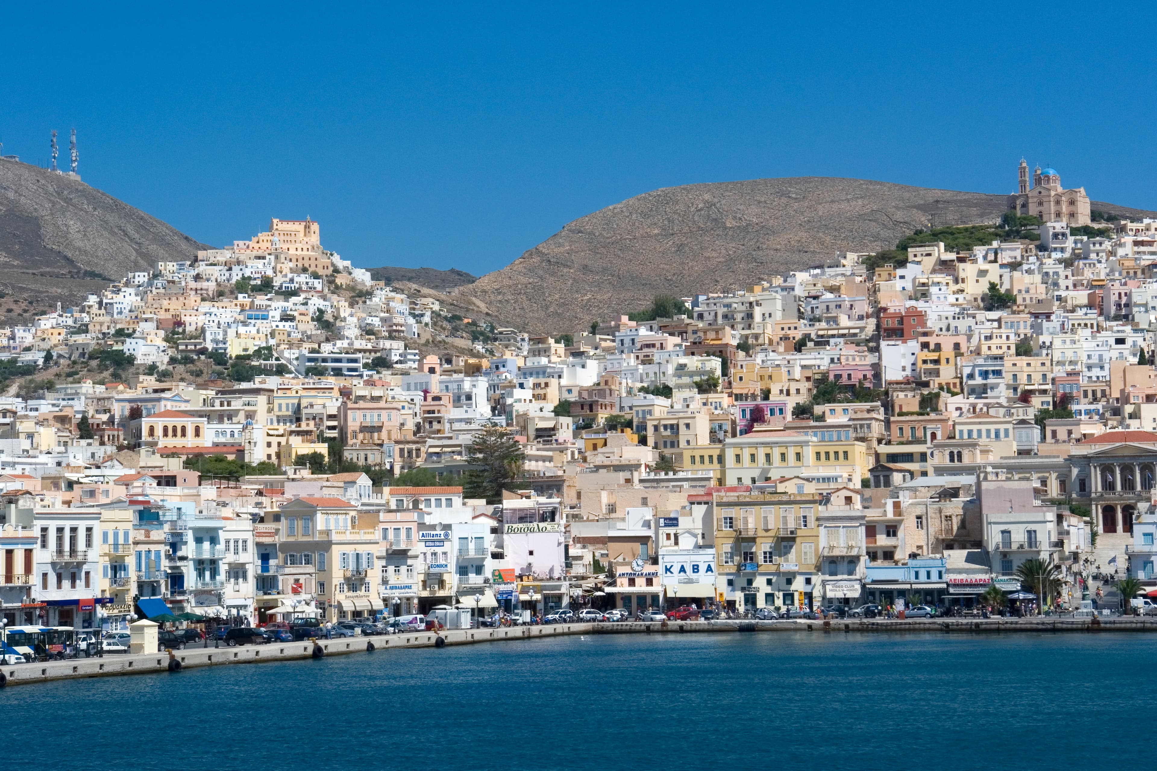 Photo: Hans Peter Schaefer, http://www.reserv-a-rt.de, CC BY-SA 3.0, via Wikimedia Commons (https://commons.wikimedia.org/wiki/File:Syros_Ano_Syros_u_Ermoupolis140707.jpg)
