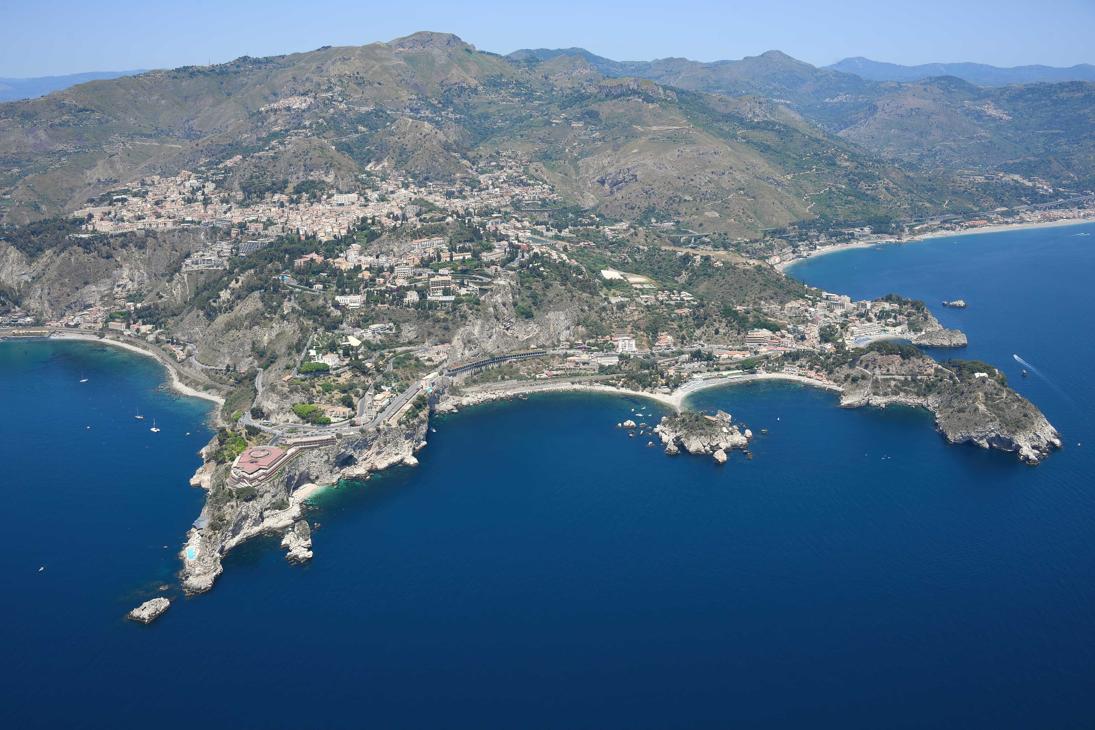 Photo: Carsten Steger, CC BY-SA 4.0, via Wikimedia Commons (https://commons.wikimedia.org/wiki/File:Aerial_image_of_the_coast_of_Taormina_(view_from_the_southeast).jpg)